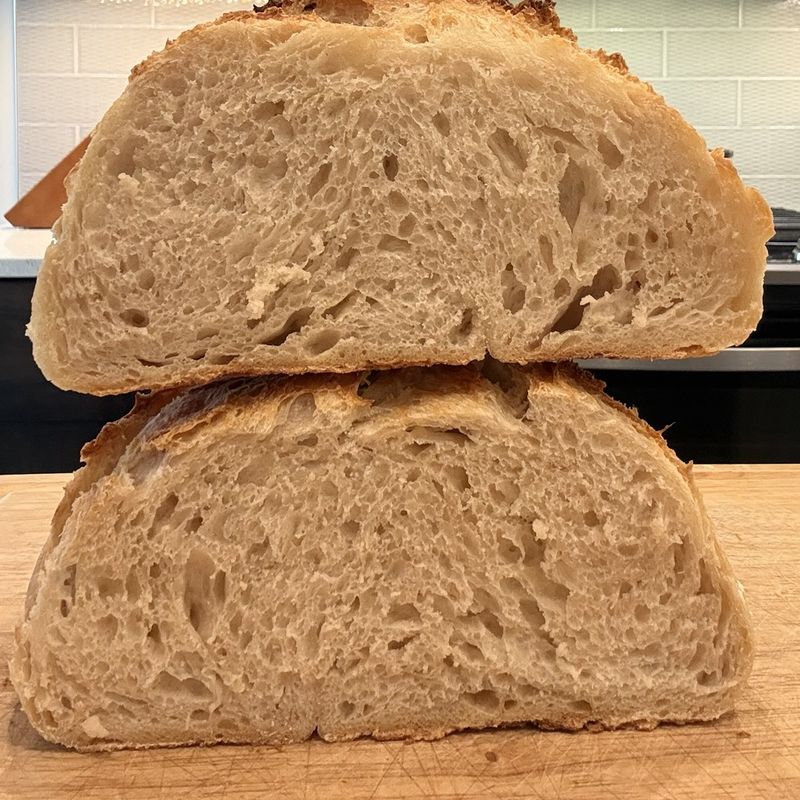 Two halves of a sourdough loaf showing an open, airy crumb