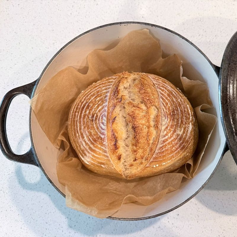 A scored sourdough boule fresh from a Dutch oven